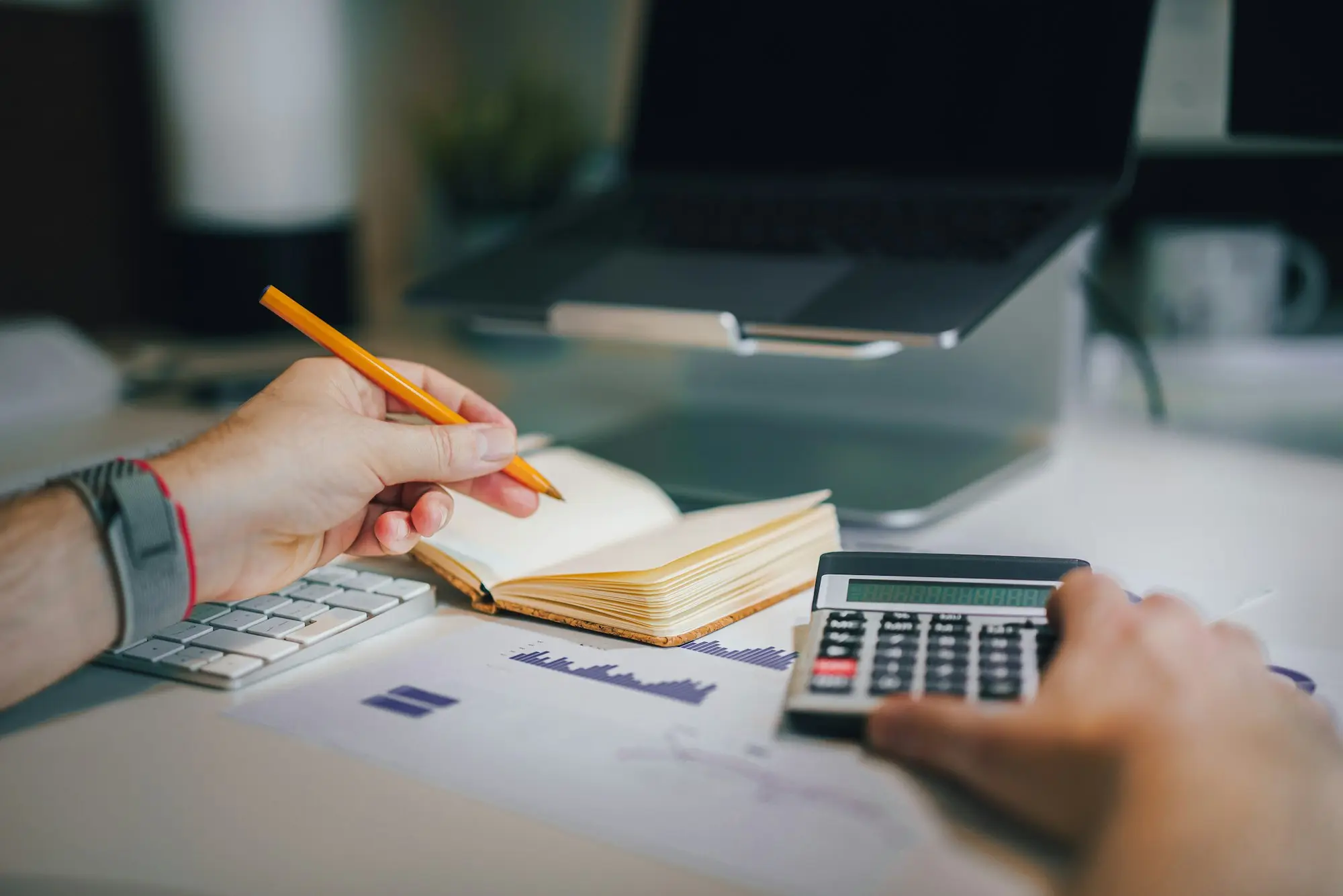 Adviser and business owner reviewing figures with a calculator