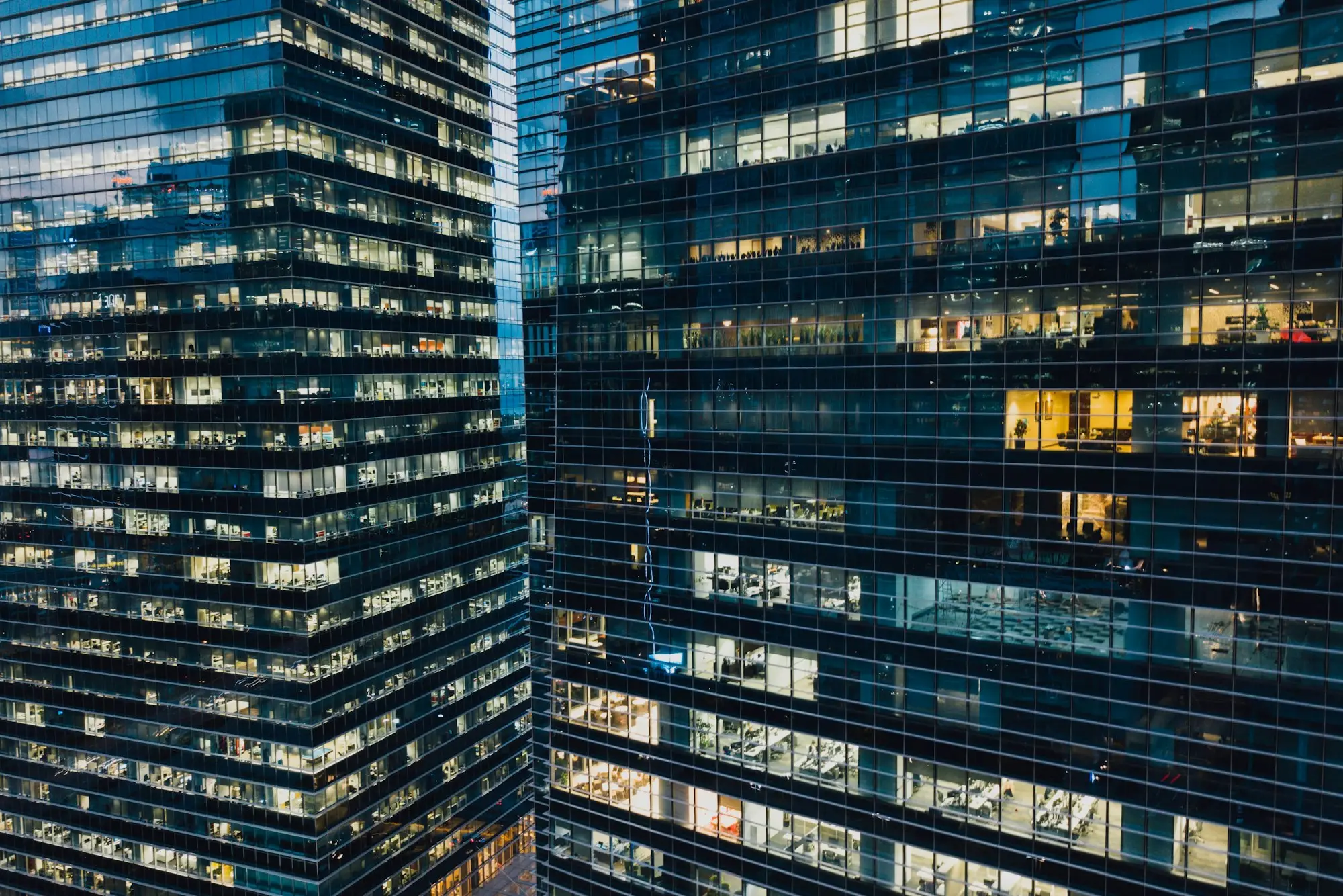 Office towers lit up at dusk in a city business district